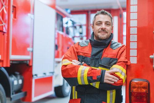 Experienced,Fire,Fighter,Man,Standing,In,Front,Of,Fire,Truck